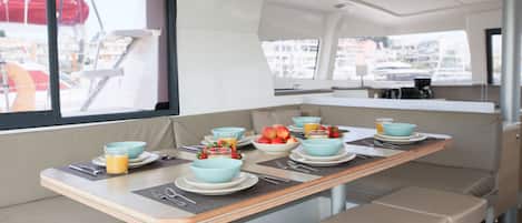 A dining area with a table set for breakfast, including bowls, plates, and cutlery.