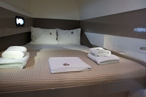 A hotel room with a bed, pillows, and neatly folded towels.