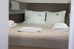 A neatly made bed with pillows, a folded towel, and a rolled towel on a textured bedspread. - Sun-kissed Sailing Adventure in the Ionian Islands (Preveza)