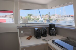A kitchen with a coffee maker, a kettle, and a tea kettle on the counter.