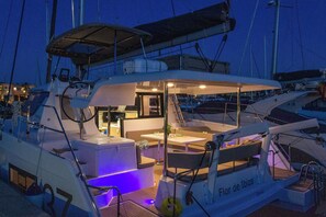 A yacht with a dining area, a kitchen, and a lounge with a pool. - Sun-Kissed Sailing: A Luxurious Beach Experience in Valencia (Denia)
