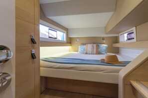 A compact bedroom with a bed, a window, and a door. - Sun-Kissed Sailing: A Luxurious Beach Experience in Valencia (Denia)