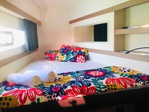 Ein Hotelzimmer mit Bett, Fenster, Spiegel und Ablagefläche.