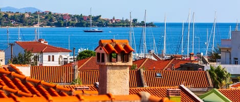 En kystby med røde tegltage, en lysthavn med både og krystalklart hav.