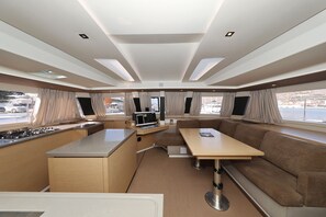 Een compact RV-interieur met een kitchenette, een eethoek en zitplaatsen.