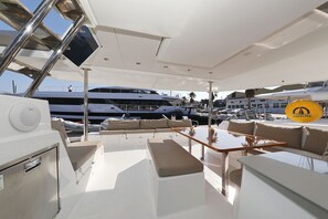 A yacht's deck with a seating area, a table, and a TV screen. - Sun-kissed Sailing Adventure in Split-Dalmatia, Croatia (Trogir)