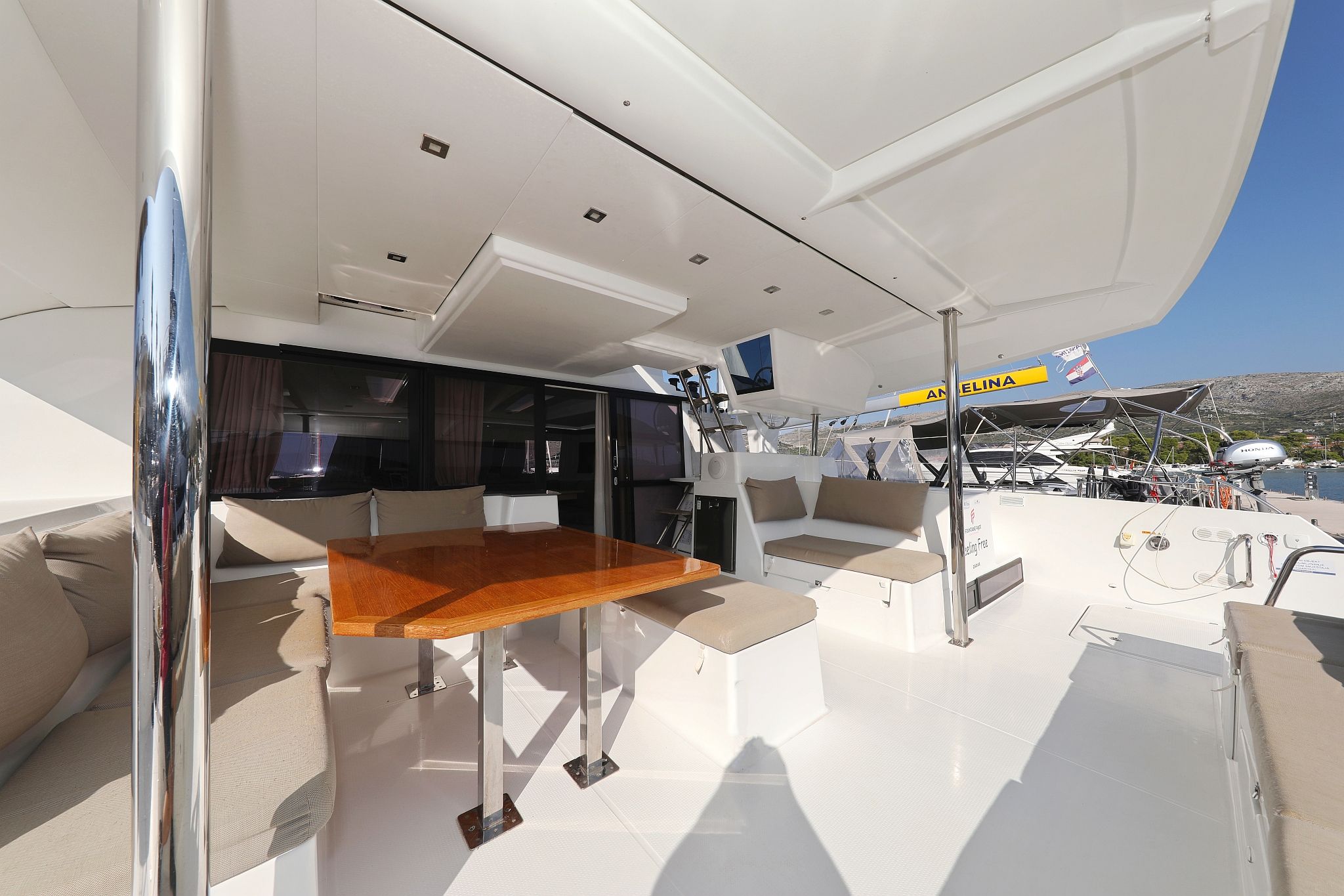 A yacht's deck with a dining area, seating, and a TV.