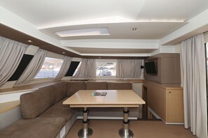 A modern interior with a sofa, table, and built-in TV. - Sun-kissed Sailing Adventure in Split-Dalmatia, Croatia (Trogir)