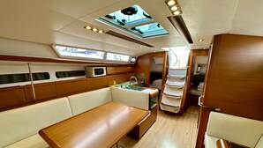A compact galley with a microwave, sink, and wooden cabinets. - Sun-Kissed Sailing Adventure in Zadar, Croatia (Bibinje)