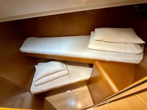 A compact, wooden bunk bed with two levels, each with a pillow and a mattress. - Sun-Kissed Sailing Adventure in Zadar, Croatia (Bibinje)