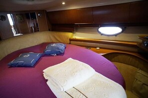 A cabin with a bed, pillows, and a headboard.