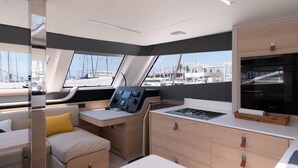 A modern interior with a control panel, seating, and storage compartments. - Sun-Kissed Sailing: A Luxurious Beach Experience in Valencia (Denia)