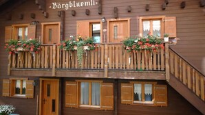 Un bâtiment en bois sur lequel est apposée une enseigne indiquant « Bärgbluemli ».
