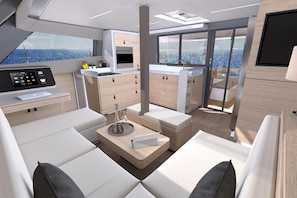 Ein modernes Interieur mit Küche, Sitzgelegenheit und großen Fenstern mit Meerblick.