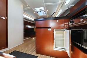 Eine kleine Küche mit Kühlschrank, Herd und einem kleinen Fenster.