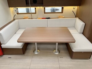 Een knus leefruimte met een centrale tafel, comfortabele zithoek en een raam met uitzicht.