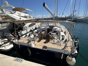 Eine Marina mit mehreren angossenen Yachten, ausgestattet mit einem gut ausgestatteten Deck, einschließlich Steuerrad, Navigationsgeräten und Sitzbereichen.