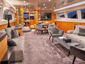 A modern interior with a sofa, armchair, dining table, and chairs. - Sun-Kissed Sailing Adventure in Split-Dalmacia, Croatia (Baška Voda)