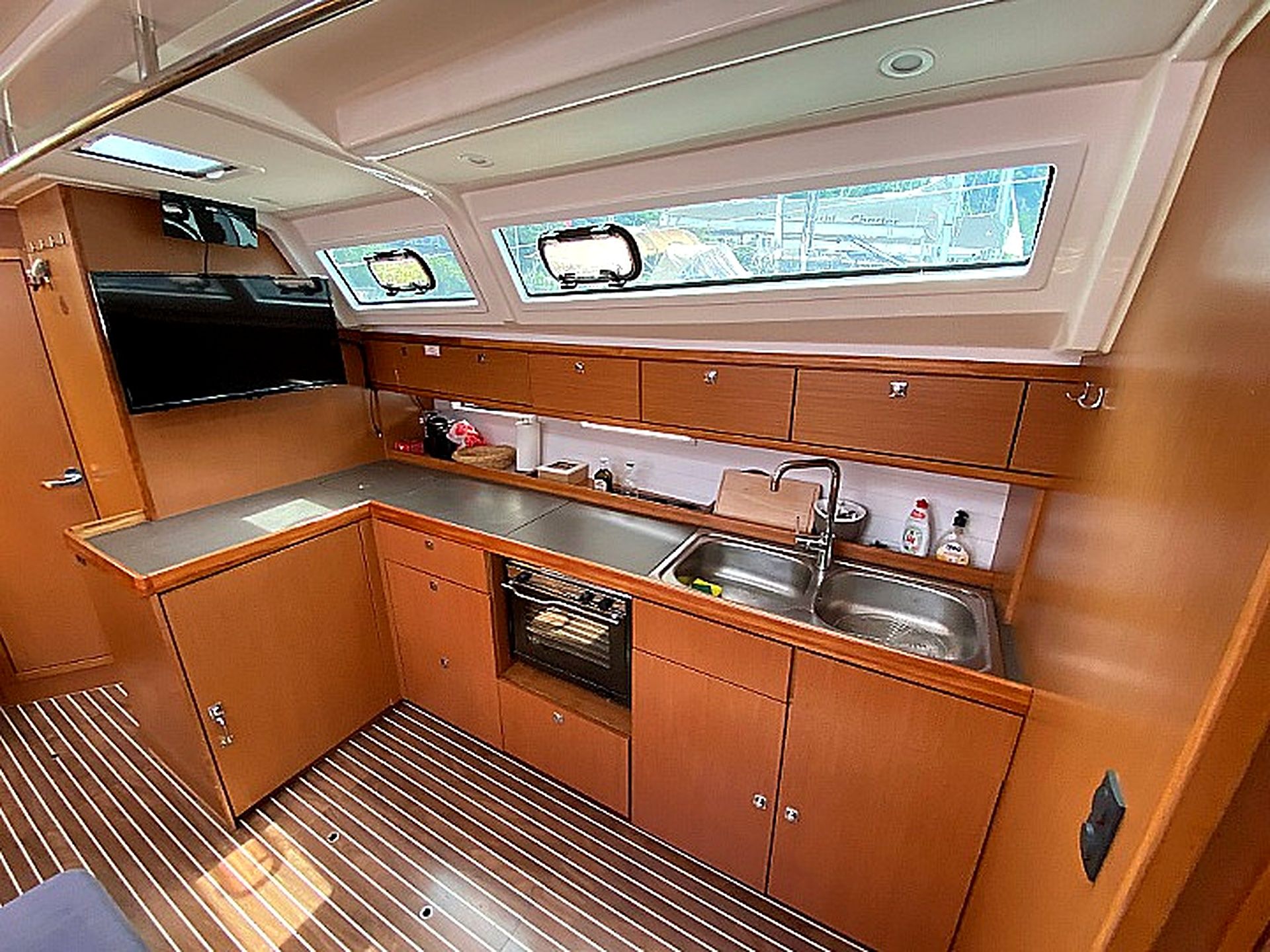 A compact kitchen with a window, a sink, and a small oven.