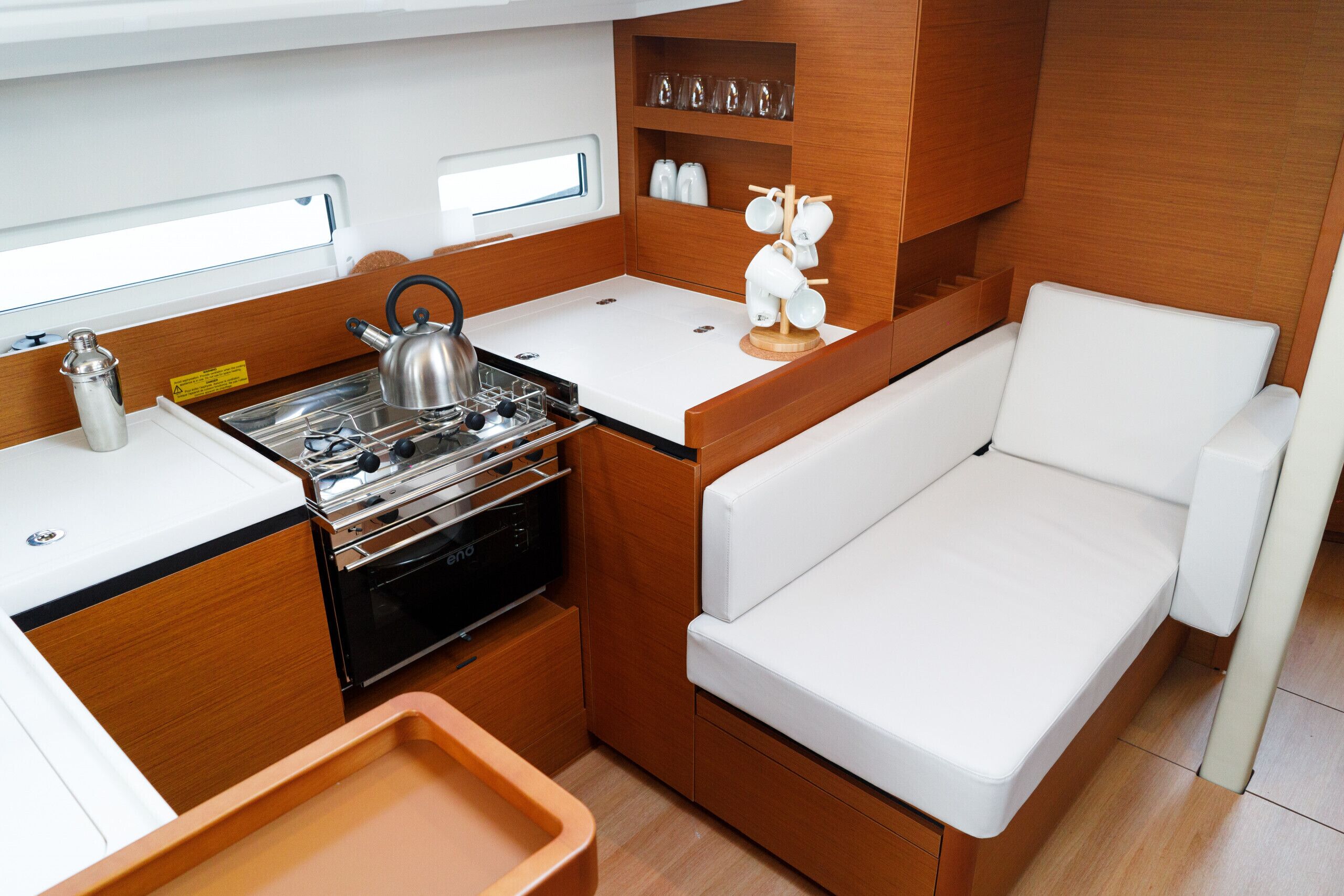 Cocina compacta con estufa, hervidor y encimera blanca.