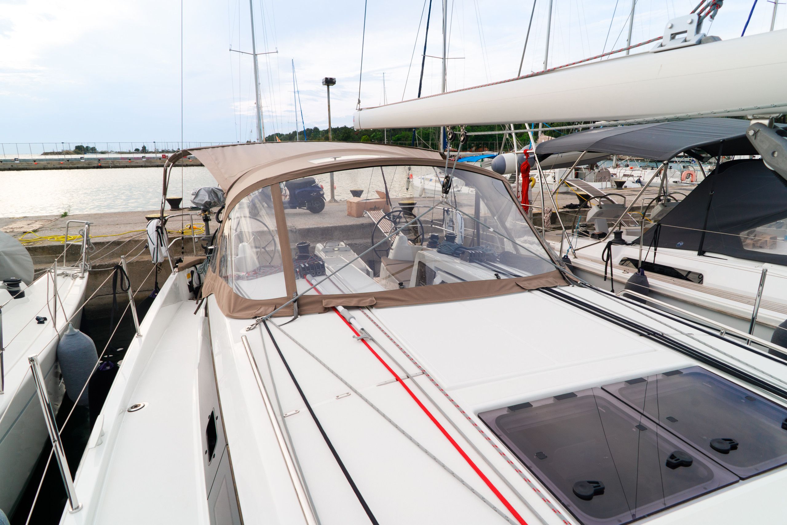 Un velero amarrado en un puerto deportivo con una cabina cubierta y diverso equipo náutico.