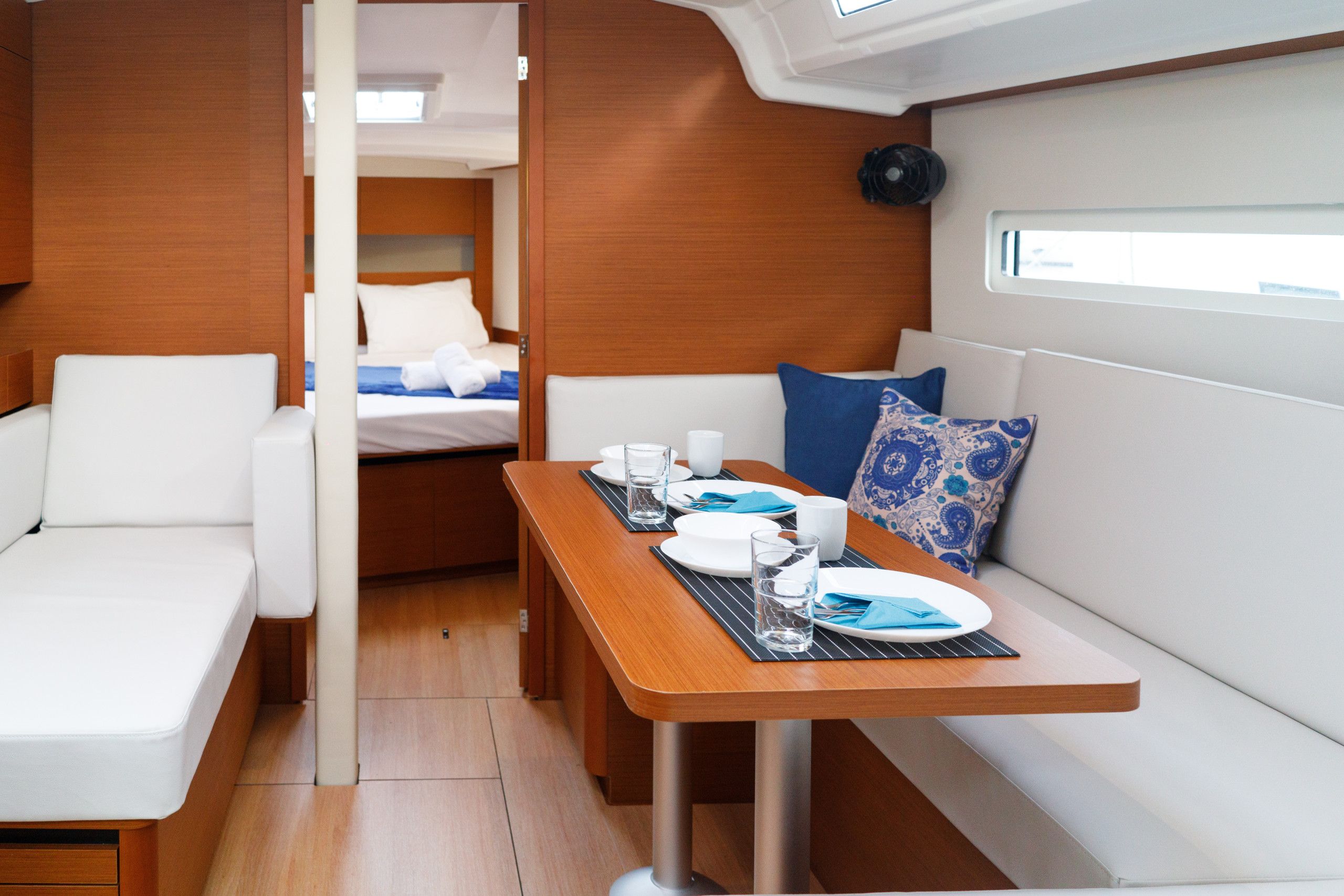 A compact interior with a dining area, a bed, and a seating space.
