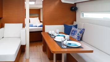 A compact interior with a dining area, a bed, and a seating space.