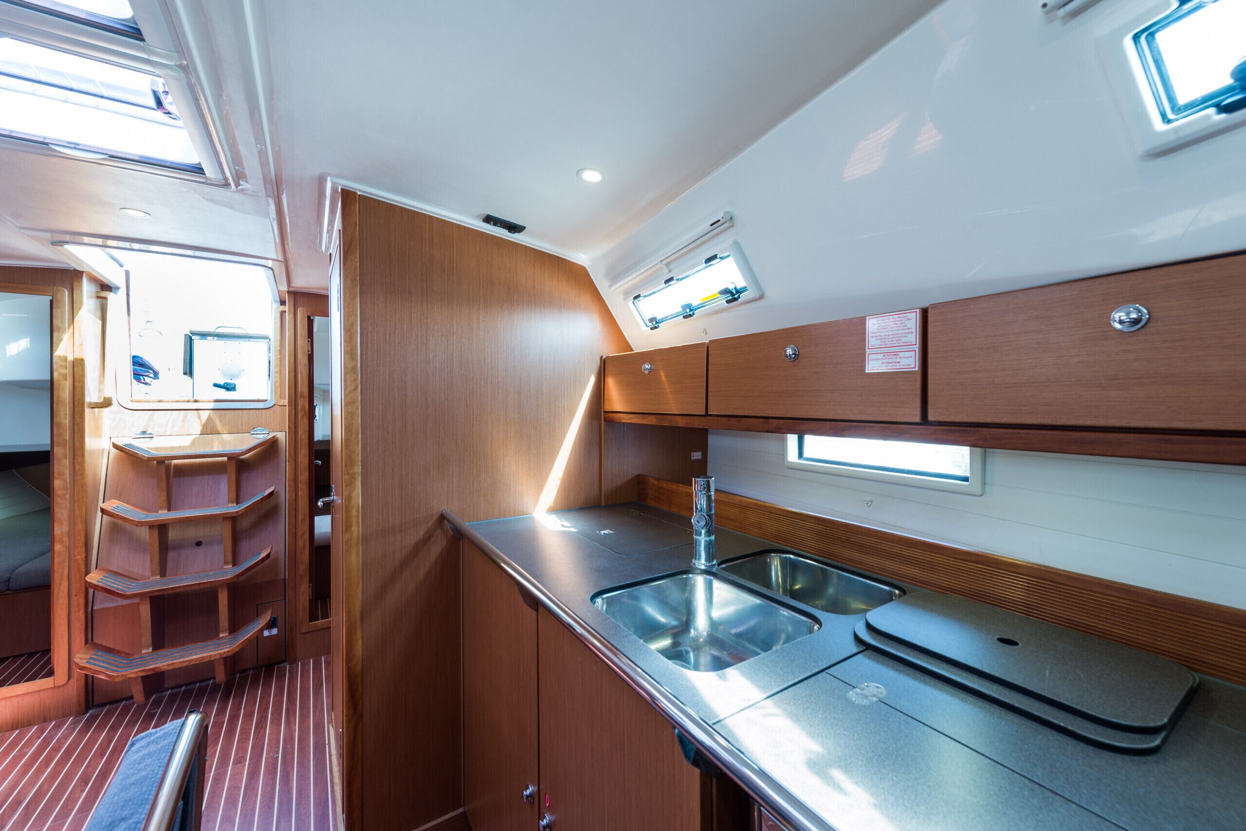 Una cocina compacta con un lavamanos, armarios de madera y una ventana.