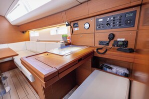 A control panel with various dials and switches, a map, and a telephone on a wooden desk in a cabin. - Sun-Kissed Sailing Adventure in Split, Croatia (Kaštel Gomilica)
