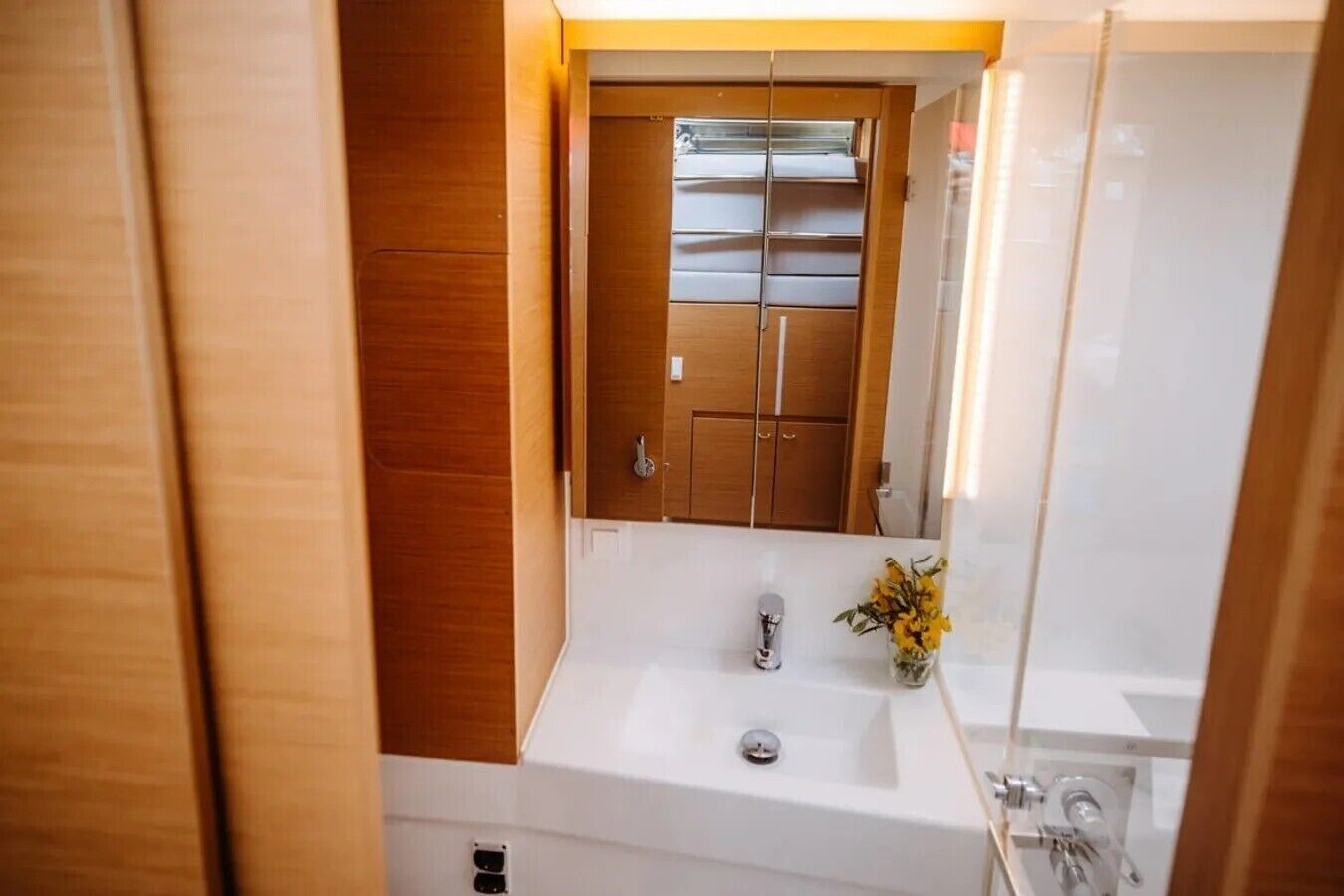 Un bany compacte amb un moble de tocador de fusta, un lavabo i un mirall.