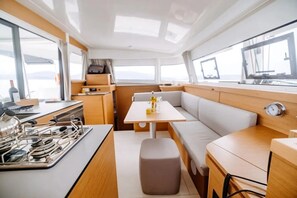 A compact galley with a stove, sink, and storage cabinets. - Sun-Kissed Sailing Adventure in the Ionian Islands (Nikiana)