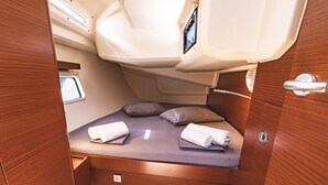 A compact, well-lit interior with a bed, pillows, and a small window. - Sun-Kissed Sailing Adventure in the Ionian Islands, Lefkada (Lefkada)