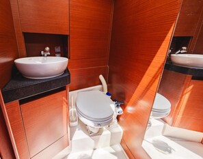 Een kleine badkamer met een wit wastafel, toilet en spiegel.