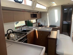 A compact kitchen with a stove, sink, and storage cabinets.