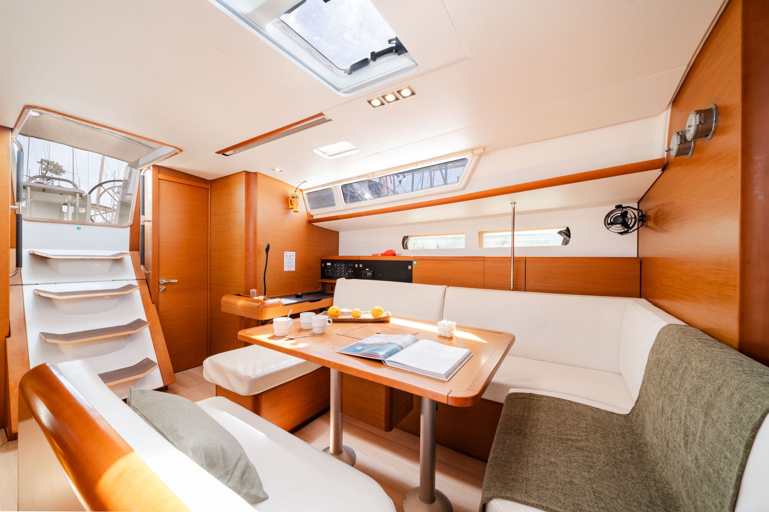 A compact interior with a dining area, a small kitchenette, and a seating area with a view of the outside.