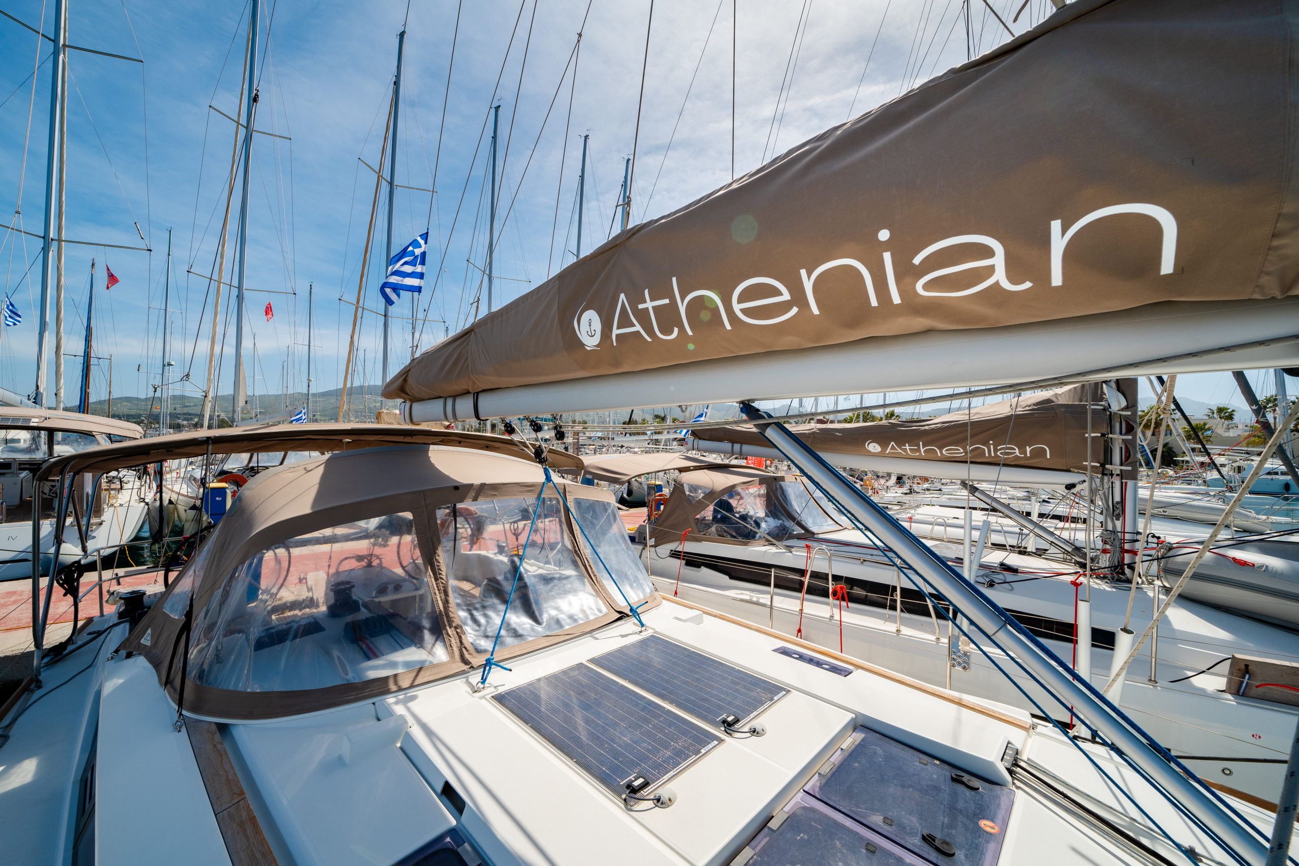 Un voilier doté d’un espace pont couvert et arborant le logo « Athénien ».