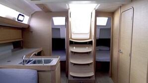 Un espacio interior compacto con kitchenette, cama y armario.