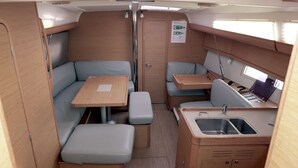 Interior de una caravana pequeña con cocina americana, zona de comedor y asientos.