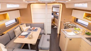 Ein kompaktes Wohnmobil-Interieur mit Essbereich, Küchenzeile und Sitzgelegenheiten.