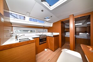 A compact galley with a sink, stove, and compact storage. - Sun-Kissed Sailing Adventure in Zadar, Croatia (Bibinje)