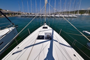 A marina with multiple sailboats docked, a clear sky, and calm water. - Sun-Kissed Sailing Adventure in Zadar, Croatia (Bibinje)