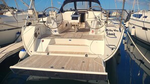 A boat docked at a marina with a wooden deck, a steering wheel, and a name 'Milky Way' visible on the side. - Sun-Kissed Sailing Adventure in Zadar, Croatia (Drage)