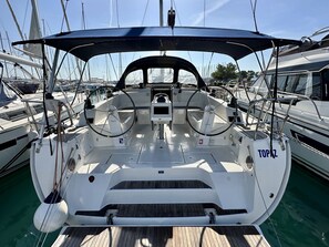 Das Deck eines Bootes mit Steuer, Armaturenbrett und dem Namen 'TOPAZ' an der Seite.