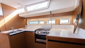 A compact galley kitchen with a stove, sink, and a window. - Sun-Kissed Sailing Adventure in Tenerife, Islas Canarias (Las Galletas)