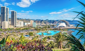 A cityscape with modern buildings, a large pool area, and a distinctive white dome structure.