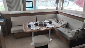En matplats med ett bord för fyra personer, en soffa och utsikt över hamnen.
