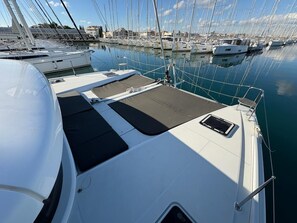 A marina with multiple boats docked, a covered deck area, and a clear sky. - Sun-Kissed Sailing Adventure in Zadar, Croatia (Bibinje)