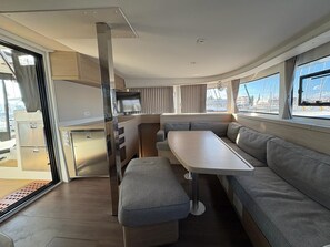 A compact RV interior with a dining area, seating, and a kitchenette. - Sun-Kissed Sailing Adventure in Zadar, Croatia (Bibinje)