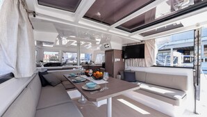 A modern interior with a dining area, seating, and a TV. - Sun-Kissed Sailing Adventure in Zadar, Croatia (Zadar)