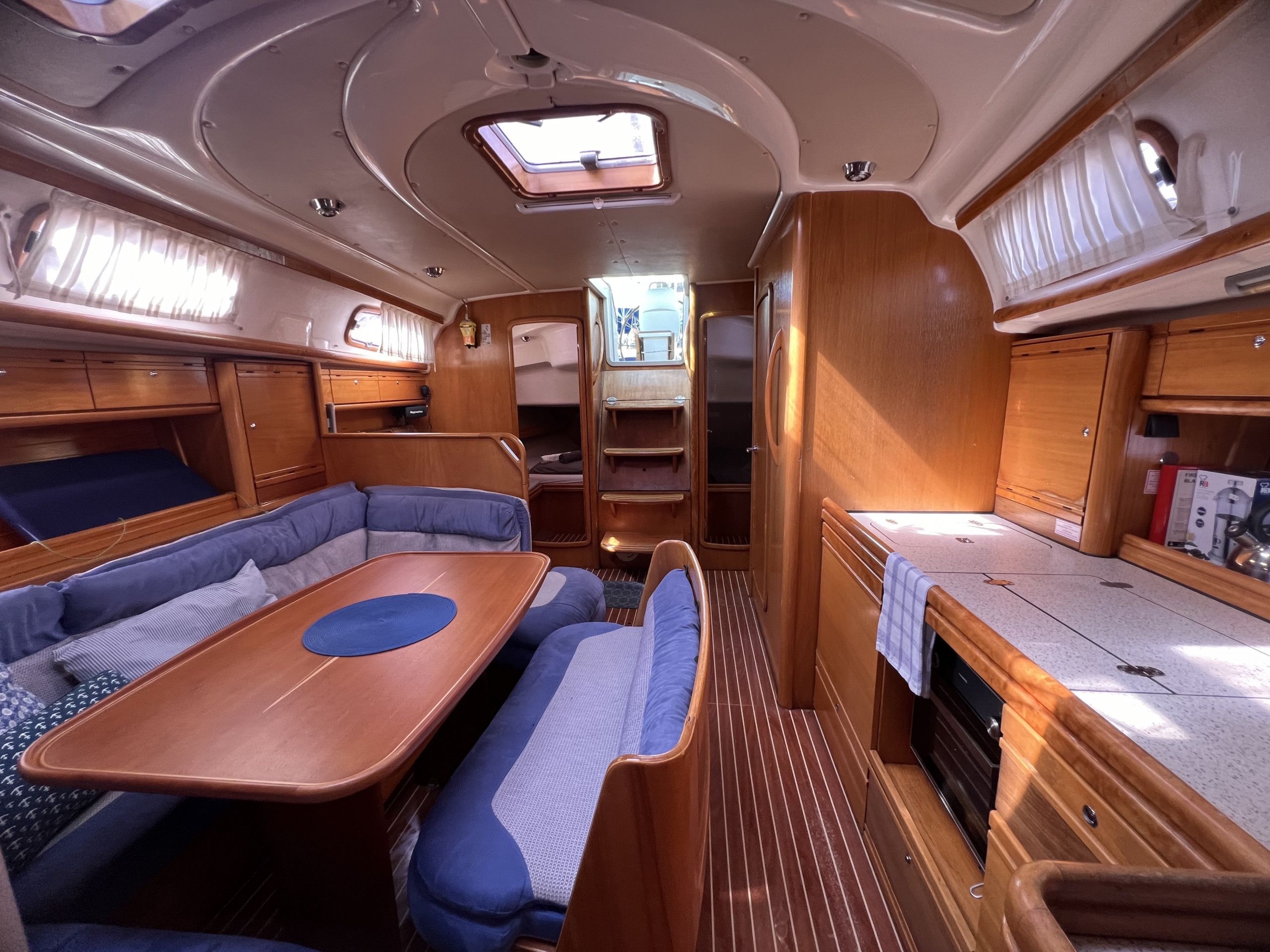 Interior d'una caravana compacta amb zona de dinar, seients i una cuineta petita.
